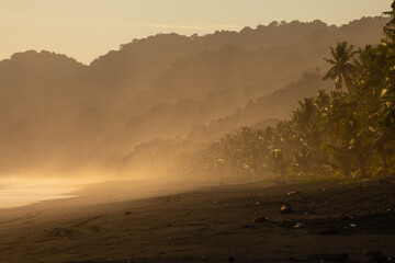 The low sun's golden light illuminates the ocean spray on Carate Beach, with views of Corcovado NP at sunset. Costa Rica. © jiriviehmann