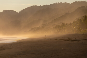 The low sun's golden light illuminates the ocean spray on Carate Beach, with views of Corcovado NP at sunset. Costa Rica. © jiriviehmann