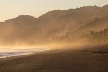 The low sun's golden light illuminates the ocean spray on Carate Beach, with views of Corcovado NP at sunset. Costa Rica. © jiriviehmann