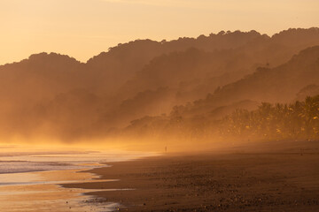 The low sun's golden light illuminates the ocean spray on Carate Beach, with views of Corcovado NP at sunset. Costa Rica. © jiriviehmann