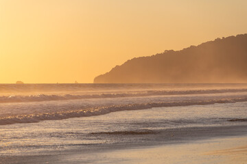 The low sun's golden light illuminates the ocean spray on Carate Beach, with views of Corcovado NP at sunset. Costa Rica. © jiriviehmann