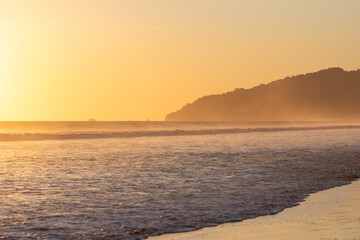 The low sun's golden light illuminates the ocean spray on Carate Beach, with views of Corcovado NP at sunset. Costa Rica. © jiriviehmann
