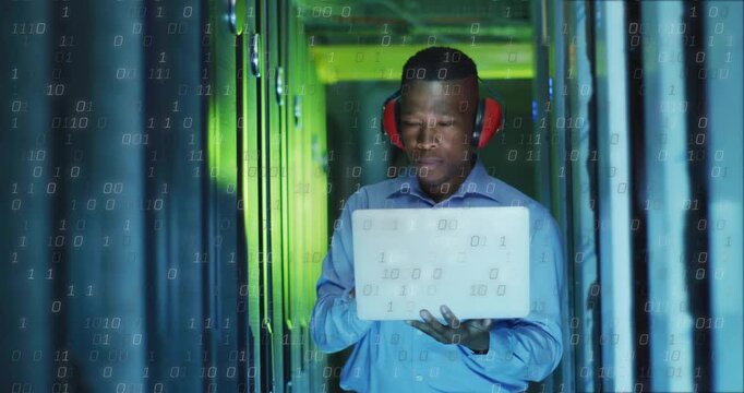 Data center technician studying white laptop in server aisle, binary overlay scanning racks