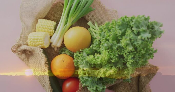 Kale, citrus, tomato bundle resting on burlap, light streak shifting, highlighting for food ads