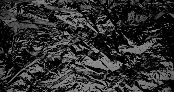 Crinkled Black Foil Texture Abstract. Stop motion animation of dark crumpled metallic foil with sharp angular folds.