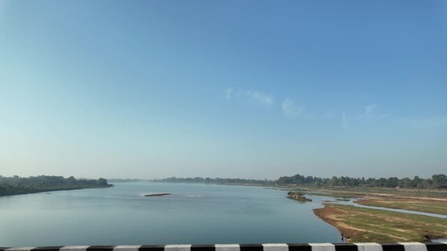 Wide River Landscape with Clear Blue Sky and Calm Water View