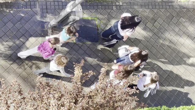 Grupo de ni&ntilde;as peque&ntilde;as de colegio y amigas en pandilla paseando juntas vistas desde arriba en perspectiva