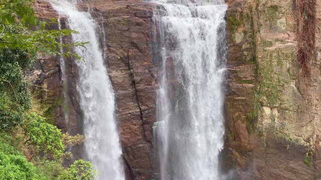 Ramboda Waterfall near Nuwara Eliya town in Sri Lanka. Majestic Double Stream Waterfall Cascade Down Rocky Cliff Face in Lush Green Jungle Environment: Nature's Beauty