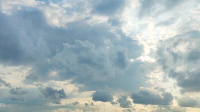 Dramatic sky timelapse with cumulus clouds moving as bright sun rays pierce through the gaps, creating a majestic and spiritual atmosphere