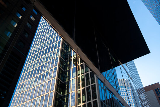 Modern glass skyscraper facade with strong contrast and reflection seen from sharp angle in urban setting showing corporate architecture and scale