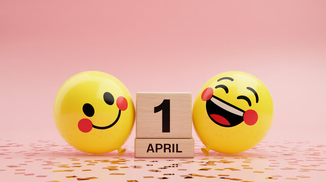 April Fools Day celebration concept with two happy yellow emoji faces. Wooden block calendar showing first of April date with confetti background.