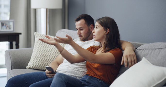 Phone, argue and couple watching tv on couch, bonding distraction or upset for missing movie scene. Talk, unhappy partner or people with mobile for social media in home, lack of attention or presence