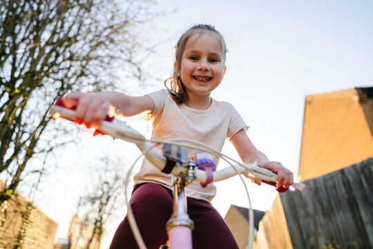 Smiling child riding bicycle outdoors enjoying family time in spring
