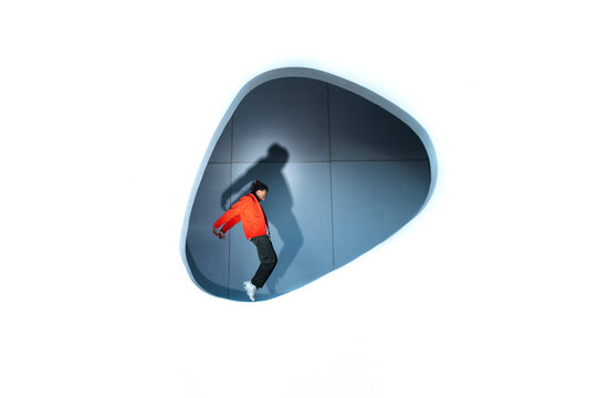Model in red jacket posing dynamically in modern white architectural space