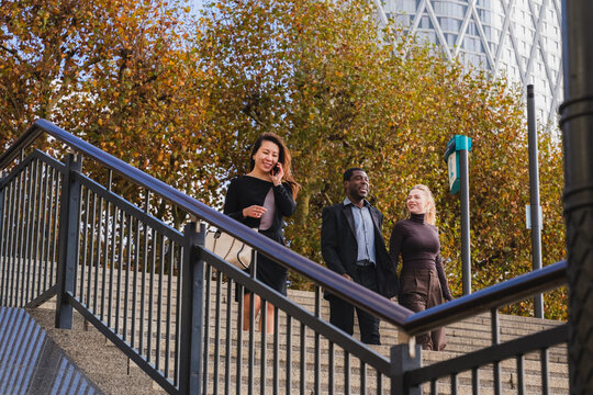 Business colleagues walking and talking outdoors on city stairs