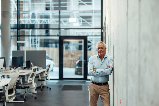 Managing director standing confidently in modern office workspace