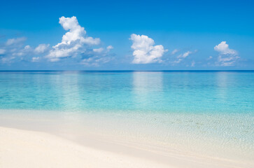 Fototapeta premium Calm tropical sea landscape with beautiful white beach sand and turquoise sea water reflecting clouds