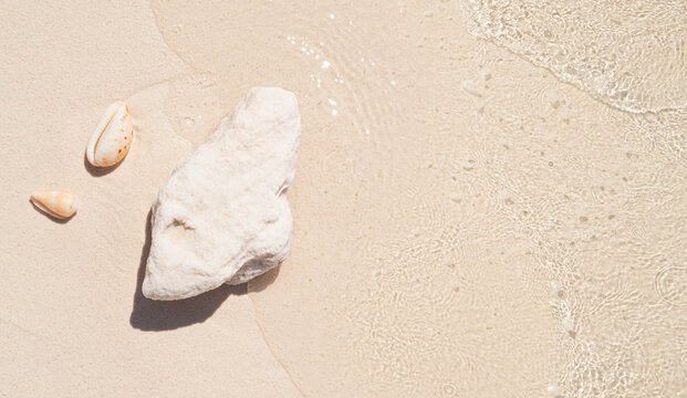 Transparent sea water view from above with white sand beach, coral stone and shells