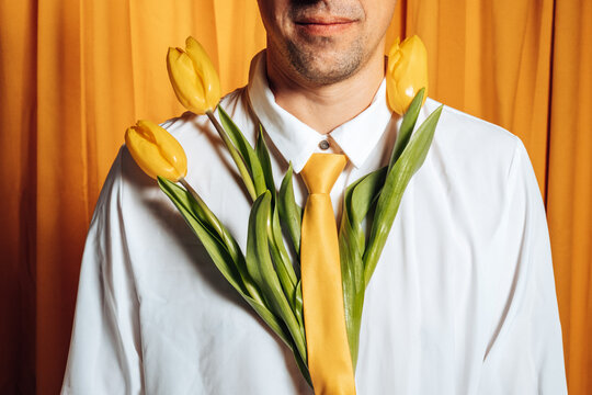 Man with yellow tulips and matching tie showing sensitivity