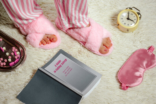 Slippers and sleep accessories with insomnia humor in bedroom setting