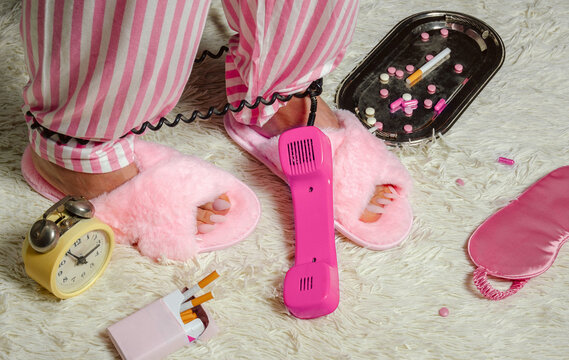 Insomnia concept with slippers pills cigarettes and phone at night