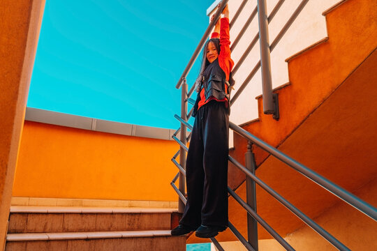 Youthful dancer moving energetically on urban stairs outdoors