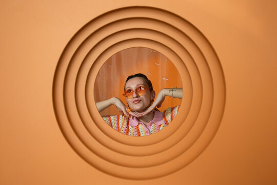 Stylish person posing with sunglasses and bubbles in retro orange setting