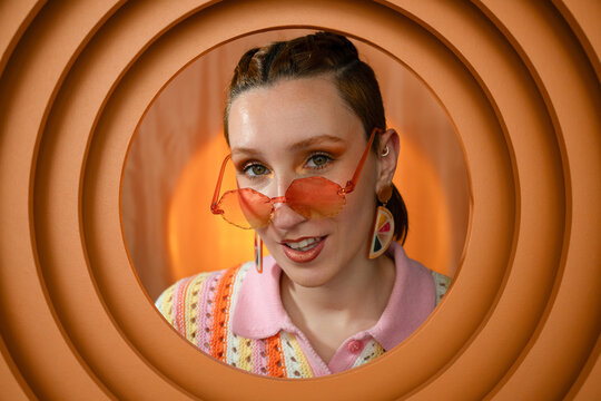 Stylish portrait of person with retro sunglasses in orange setting