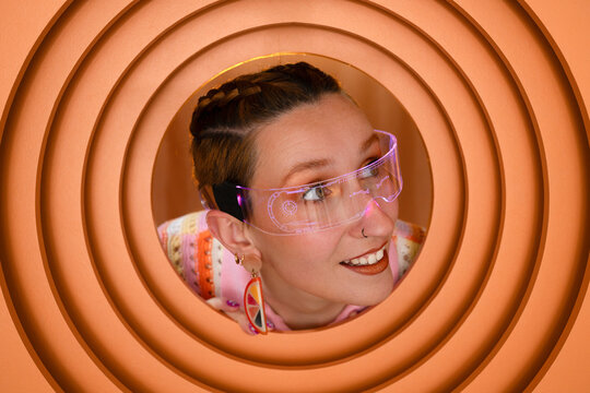 Smiling person wearing neon futuristic glasses in circular set