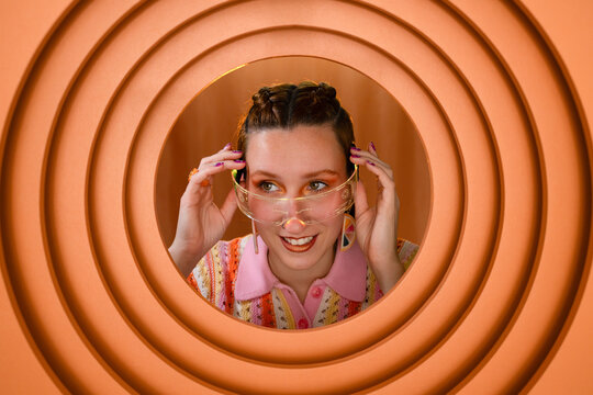 Smiling person wearing smartglasses in a colorful circular setting