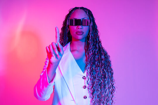 Woman in white blazer with AR glasses interacting on colored background