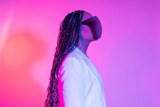 Woman in white blazer posing with futuristic AR glasses in studio