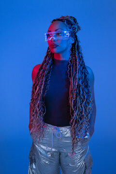 Fashion portrait with AR glasses and braids in blue studio light