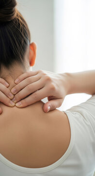 Woman rubbing neck to relieve muscle tension in morning. Exhausted girl massaging stiff shoulders after sleep. Health care concept, pain relief, physical therapy and body stress relief.
