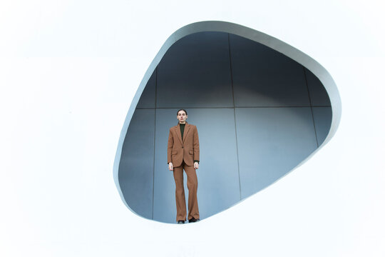 Businesswoman in formal suit standing in geometric minimalist setting