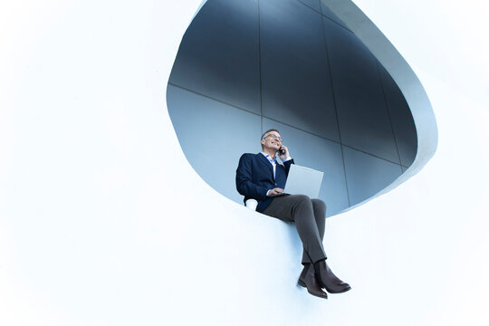 Business professional multitasking with laptop and smartphone in Barcelona