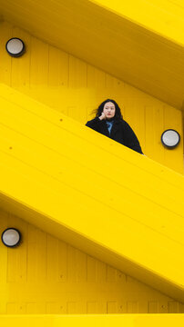 Woman standing on yellow urban geometric staircase outdoors