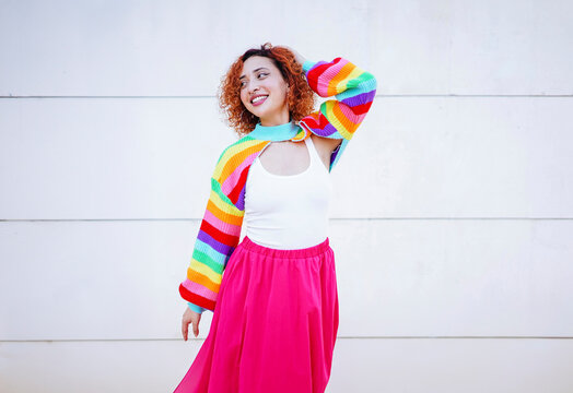 Smiling dancer in colorful rainbow sweater and pink skirt outdoors