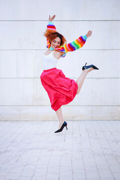 Happy dancer in colorful outfit jumping outdoors in spring