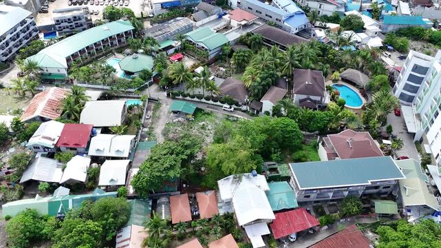Drone flyover of tropical village architecture and palm trees in Bohol, holiday destination