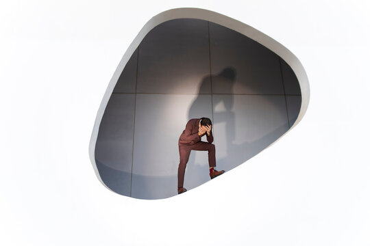 Businessman in suit showing stress and anxiety indoors with shadow