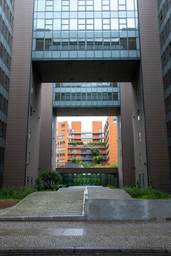 Framed courtyard passage in modern office architecture with urban symmetry and strong perspective creating an empty spatial portal and clean geometry