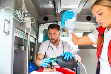 Doctor performing medical procedure in ambulance on patient, Healthcare and Medicine concept. Professional paramedic team providing emergency care. First responder clinical life saving rescue work. © Graphicroyalty