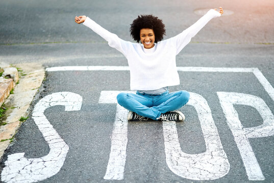 Portrait, stop sign and woman with celebration, road and travel with joy, adventure or cheerful in street. African person, outdoor or girl on ground, relax or journey with reaction, smile or vacation