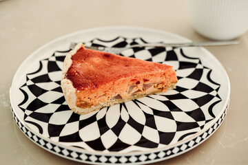 gourmet pear and cheese tart slice on black and white plate