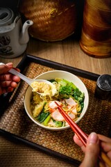 Egg noodles with roasted pork and wontons in soup, Thai-Chinese style.