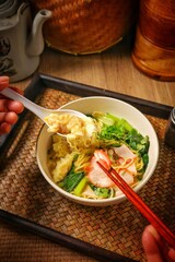 Egg noodles with roasted pork and wontons in soup, Thai-Chinese style.