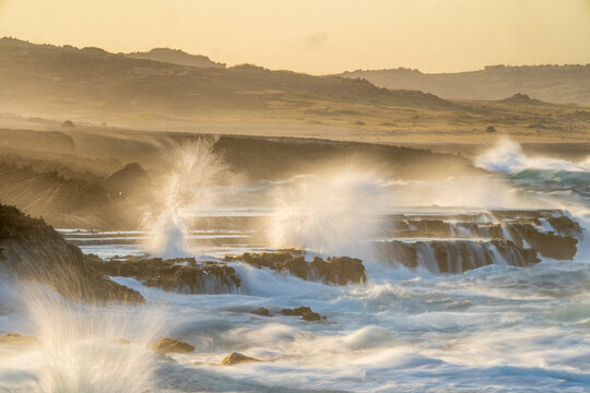Breaking waves on the rocky shore at dusk, Aruba, Caribbean Sea. March, 2024. 