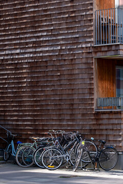 Bicycle parked at a rack along an urban street with wood facade supporting transportation commuting in oslo and everyday city mobility lifestyle