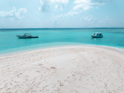 Aerial view of boats bob gently in the turquoise water, contrasting with the pristine white sand beach, Dhidhdhoo, Thiladhunmathee Uthuruburi, Maldives.